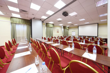 Back of red chairs and wooden tables in empty room