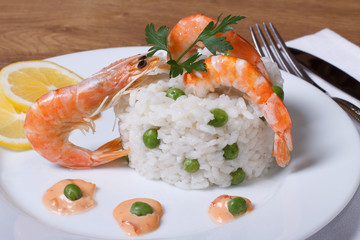 Rice with shrimps and green peas on the table