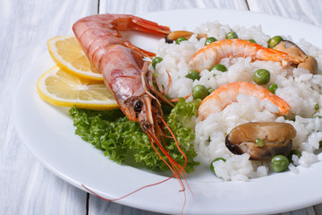 rice with seafood and vegetables in a white plate on the table