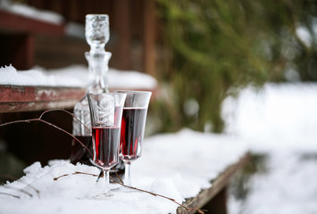 Decanter and wineglasses of red wine outdoors
