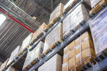 Rows of shelves with huge cardboard boxes in modern warehouse