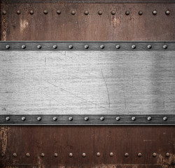 old metal plate over rusty background with rivets