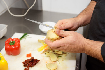 Obraz na płótnie Canvas Chef is peeling potato