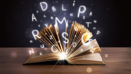 Open book with glowing letters flying out
