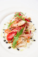 Pasta with seafood on oval porcelain plate