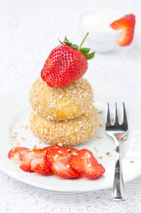 cheese pancakes with fresh strawberries on a plate and yogurt