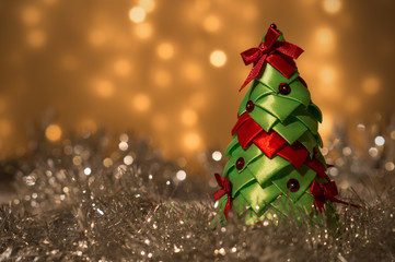 Dekoracja świąteczna - zielona choinka ze wstążek na tle lampek - obrazy, fototapety, plakaty