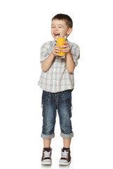 Little boy with a glass of juice laughs.