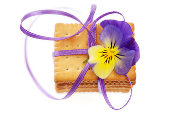 Sweet biscuits tied with a purple ribbon on a white background