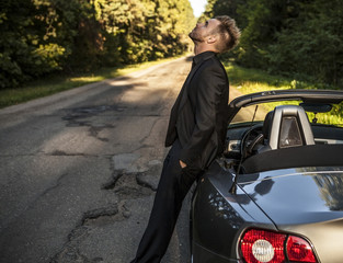 Elegant young handsome man and convertible car.
