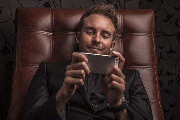 Handsome young business man relaxing on luxury sofa.