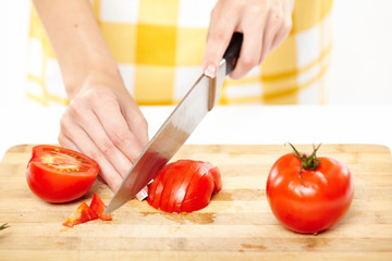 Slicing the tomato on a wooden board
