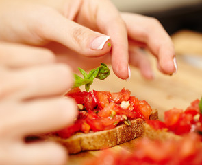 Decorating the tomato bruschettas with basil