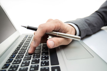 Close-up of male hands typing on laptop