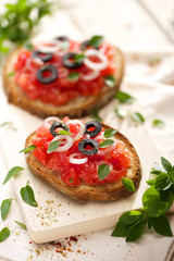 Bruschetta with fresh tomato, olives, onion and oregano
