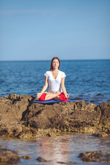 Fototapeta na wymiar Young beautiful woman on the beach making yoga
