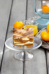 Piece of toffee and vanilla cake on transparent glass cake stand