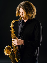 Obraz na płótnie Canvas Teenager playing the saxophone