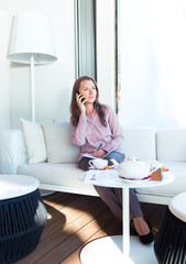 Happy businesswoman talking on the phone and writing in organize