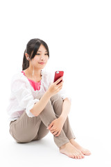 Naklejka premium young asian woman listening to music on white background