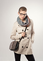 Beautiful blonde wearing fashionable coat, scarf ang leather bag