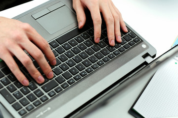 Fototapeta na wymiar Closeup image of hands typing on laptop