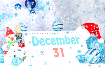 Calendar with New Year decorations on winter background