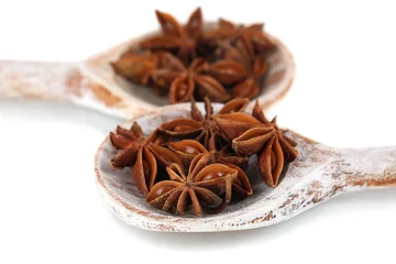 Foto op Canvas Star anise in wooden spoons, isolated on white © Africa Studio