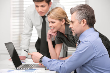 Senior  business man showing something on laptop.