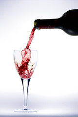 Obraz na płótnie Canvas Butelka Wlewanie wina czerwonego w szkle