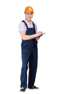 Builder in orange hard hat writing on a tablet with documents 