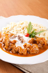 Naklejka premium Pork knuckle of ham with peeled almonds and pasta