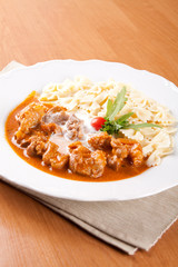 Pork knuckle of ham with peeled almonds and pasta