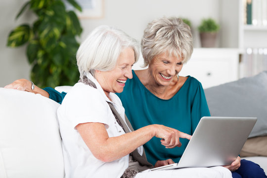 zwei ältere damen mit laptop zu hause
