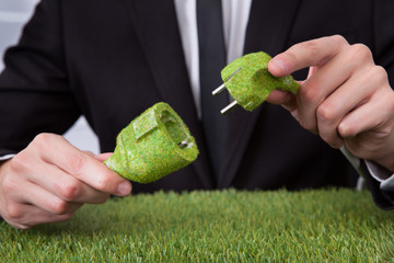 Man Holding Grass Covered Cable