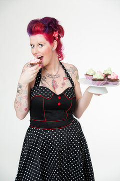 Junge Frau isst Cupcakes
