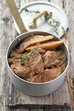 meat goulash with quince on a rustic wooden background