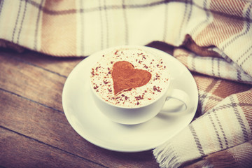 Cup with coffee and scarf.