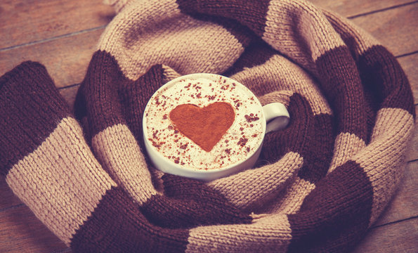 Cup with coffee and scarf.
