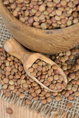 brown lentils in a wooden spoon