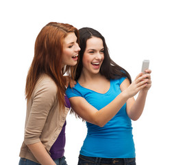 two smiling teenagers with smartphone