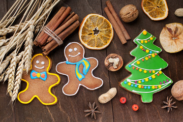 Christmas gingerbread cookie and spices on wooden table.