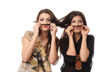 Girls having fun and making mustaches out of each others hair