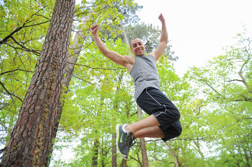 Athletic man jumping in forest © FreeProd