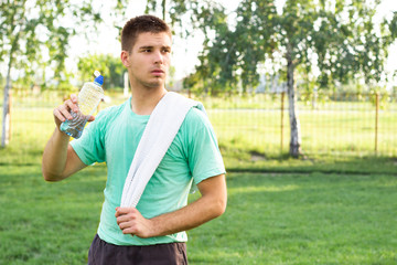 Handsome man holding plastic bottle