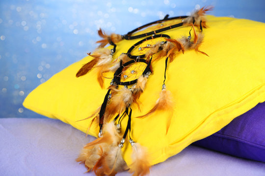 Beautiful dream catcher and pillows on blue background
