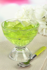 Tasty jelly cubes in bowl on table on light background