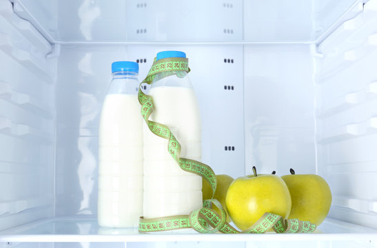 Conceptual photo of diet: apple and milk bottle with measuring