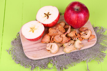 Dried apples, on cutting board,  on color wooden background