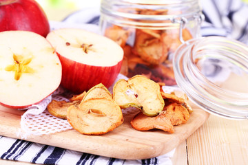 Dried apples in glass jar, on color wooden background